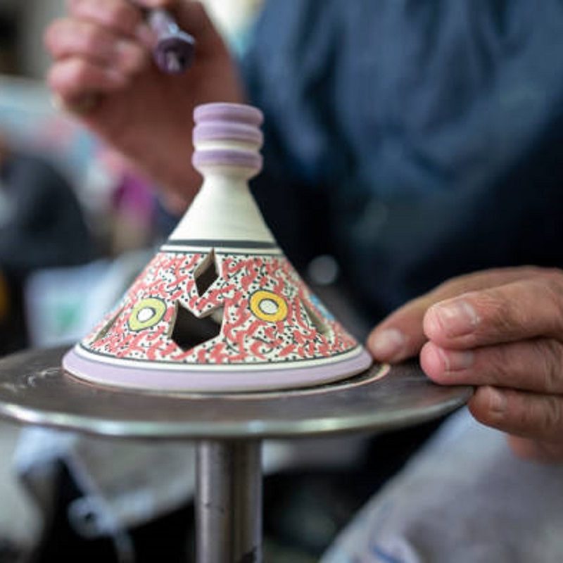 An artisan paints a tagine in Fez, Morocco.